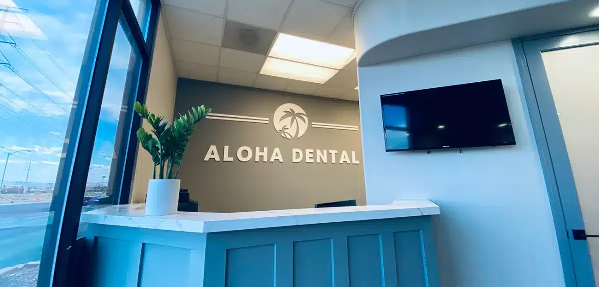 Modern dental office reception desk with "Aloha Dental" signage and blue design elements.