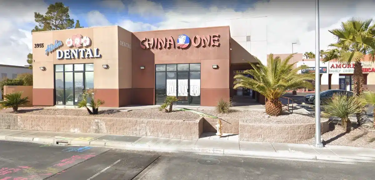 Aloha Dental Las Vegas storefront exterior with brick facade and palm trees in desert setting.